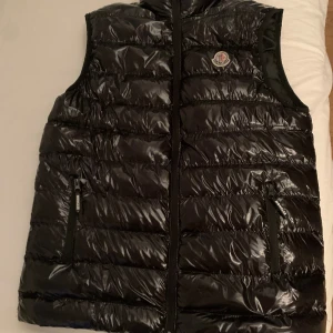 Moncler väst strl M - Moncler väst som är i bra skick och är i storlek M men passar bra på de som har L också då den är stor i storleken, det är ett litet hål på höger ficka som syns på sista bilden annars jätte fin.