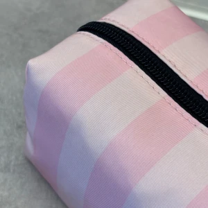 VS necessär väska 🌸🌸  Slutsålt!!!  - Säljer en superfin necessär från Victoria's Secret i rosa och vit randigt mönster. Den har en praktisk dragkedja och är perfekt för att förvara smink eller andra småsaker. Gjord i ett slitstarkt material och enkel att ta med sig på resor. Slutsålt !!