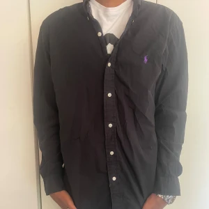 Ralph lauren skjorta strl-L - Hej! Jag säljer nu min snygga Ralph lauren skjorta i Färgen svart. Den är i bra skick och väldigt snygg och stilren. Vid fler frågor och funderingar är det bara att höra av sig!