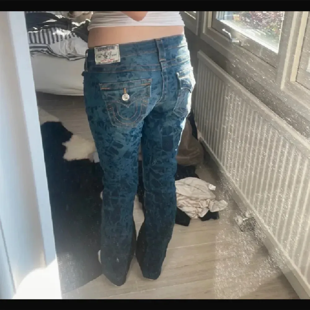 Säljer ett par snygga blå jeans från True Religion med ett coolt mönster. . Jeans & Byxor.