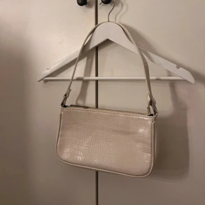 Vit liten axelväska  - Praktiskt liten handväska, som kan användas till mycket. Säljes då den inte kommit till användning💕