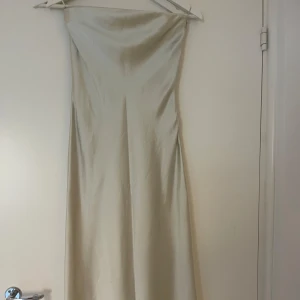 Mintgrön satinklänning - Mintgrön satinklänning med dragkedja vid sidan. Kommer ner till vaden ungefär. 