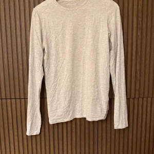 Beige långärmad tröja från Djerf Avenue - Säljer en stilren beige långärmad tröja från Djerf Avenue. Perfekt för en avslappnad look. Tröjan har en rund halsringning och är tillverkad i ett mjukt material.