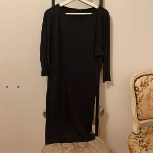 Dark grey  klänning från Massimo Dutti - Elegant dark grey klänning från Massimo Dutti i en stilren design. Klänningen har trekvartsärmar och en klassisk passform som passar perfekt för både vardag och festligare tillfällen. Tillverkad i ett mjukt och bekvämt material.