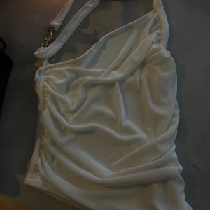 Vit topp med guldspänne - Snygg vit topp med guldspänne. Aldrig använd.