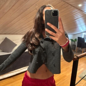 Grå croppad kavaj - Snygg grå croppad kavaj med knappar framtill. Perfekt för en stilren look. Långärmad design som passar bra till olika outfits. Kom privat om ni har några frågor! 💕