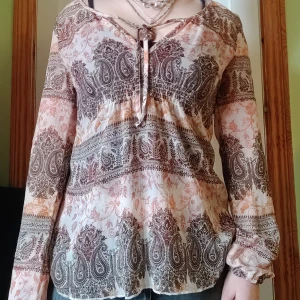 Mönstrad blus - En vacker blus med ett elegant svall. Lite genomskinlig. Snygg och bekväm. 