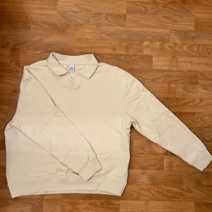 Beige pikétröja från Zara - Säljer en stilren beige pikétröja från Zara. Tröjan har en klassisk krage och långa ärmar, perfekt för en avslappnad look. Tillverkad i ett mjukt material som ger en bekväm passform. Inga fläckar eller slitage. Skriv gärna om ni har frågor allt ifrån pris till fler bilder. 