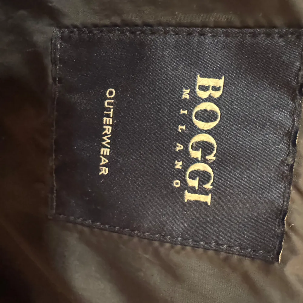 Snygg mörkblå kavaj från Boggi Milano med quiltad design och knappar framtill. Perfekt för en stilren look. Kavajen har långa ärmar och en klassisk krage. Funkar bäst på hösten och våren men funkar även i en varmare vinter. En knapp saknas men går att sy på och hänger med kavajen på köp. Förutom det är kavajen i topp skick. Modellen är drygt 190 cm.. Takit.