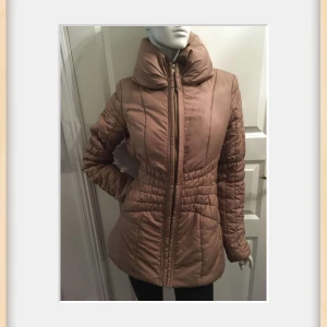 Fin jacka från Vila - Säljer en snygg beige vadderad jacka från Vila. Jackan har en hög krage och dragkedja framtill. Perfekt för kyligare dagar med sin stilrena design och bekväma passform. Märkt L, känns mindre.. Kolla mått Bröstviddmätt rakt över: 49cm (98cm) Längd ca 72cm