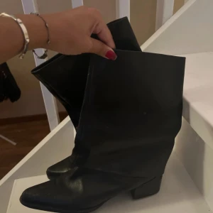 Svarta stövlar med spetsig tå - Snygga svarta stövlar i skinn med spetsig tå och låg klack. Perfekta för en stilren look.