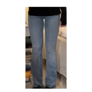 Blå bootcut jeans - Snygga blå bootcut jeans med fransiga benslut. Klassisk femficksdesign och knappgylf. 