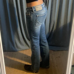 Lågmidjade diesel jeans - Lågmidjade ljusblå jeans från diesel. Jeansen är straight/bootcut med  detaljer på bakfickorna💕Storlek: W28 L30. (Midjan sitter mer som 26/27) Midjemått: ca 37cm Innerbenslängd: ca 75cm (fållarna längst ned på byxorna är uppsprättade då de varit uppsydda tidigare)