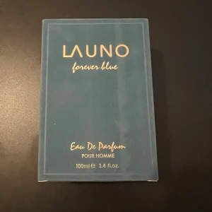 Launo Forever Blue Eau De Parfum - Launo Forever Blue Eau De Parfum för män, 100 ml. Flaskan har en elegant blå design med gulddetaljer och en matchande blå kork. Perfekt för den som söker en sofistikerad och fräsch doft. Bara testat den,
