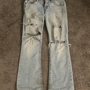 Levis 515 Bootcut Jeans - Snygga ljusblå Levis 515 bootcut jeans med slitna detaljer på benen.  Vet inte exakta storleken men borde passa Xs-S 