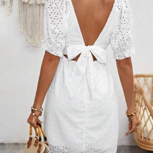 Vit klänning med puffärmar - Superfin vit klänning med puffärmar och öppen rygg. Klänningen har ett vackert broderat mönster och en knytning i ryggen. Perfekt för student och sommaren! Aldrig använd!