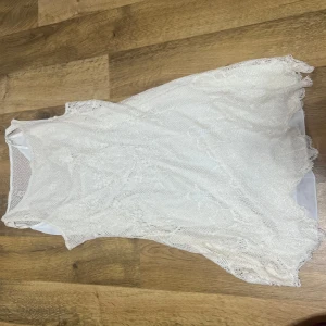 Vit spetsklänning - Säljer en vacker vit spetsklänning med ärmlös design. Perfekt för sommarens alla tillfällen. Klänningen har en luftig passform och ett elegant utseende. Priset går att diskuteras