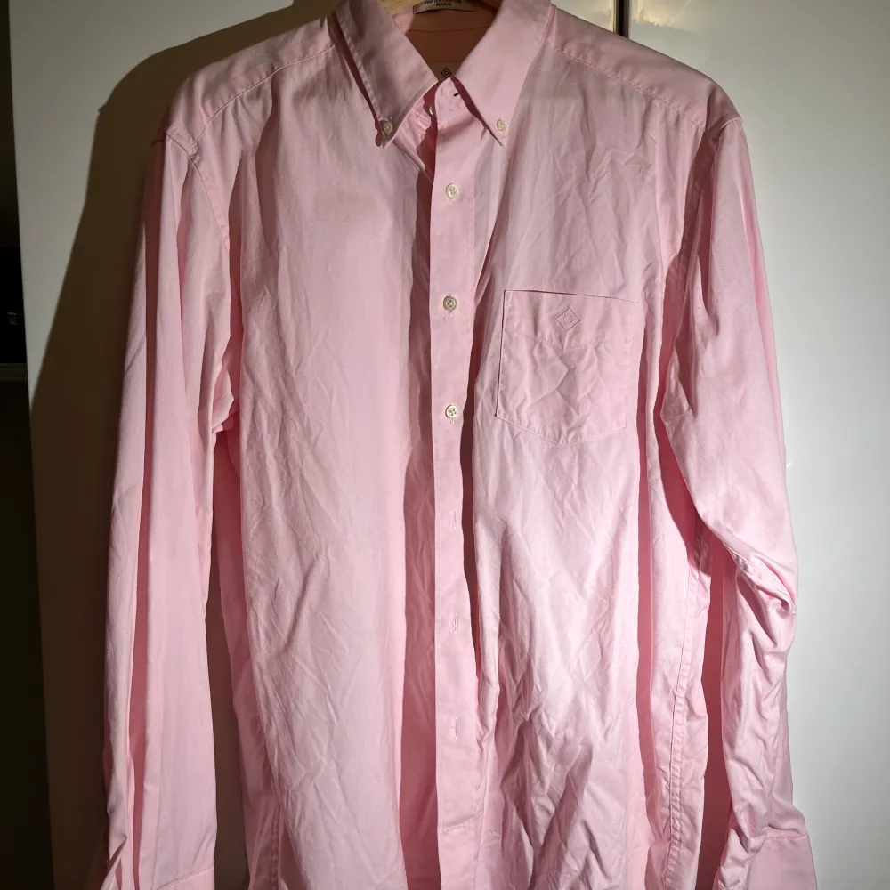 Snygg rosa skjorta från Gant i bomull. Den har en klassisk krage och knappar framtill. Perfekt för en stilren look.. Paidat.
