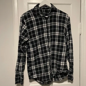 Flanellskjorta - Snygg svartvit rutig flanellskjorta från Pull&Bear i en avslappnad passform. Mycket bra skick. Storlek xs. Skriv vid frågor eller fler bilder