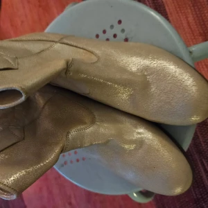 Guldiga boots från Unisa - Snygga guldiga boots från Unisa med rund tå och låg klack. Perfekta för att ge en glittrig touch till din outfit. Tillverkade i skinn för en lyxig känsla.