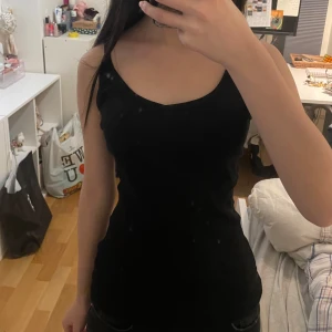 Svart linnetopp från Esmara - Säljer en svart linnetopp från Esmara i storlek M. Toppen är tillverkad av ekologisk bomull och elastan, vilket ger en skön och stretchig passform. Perfekt för en stilren och enkel look. Beklagar för smutsig spegel