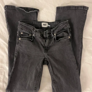 Grå/svarta jeansbyxor  - Snygga grå jeansbyxor med dragkedja och knapp framtill. Byxorna har en klassisk femficksdesign och är perfekta för en avslappnad stil. Jeansens gylf åker ner vilket är varför ett snöre har knytits på gylfen och används på samma sätt som bilderna demonsterar. Byxorna är storlekt xxs och längden short.