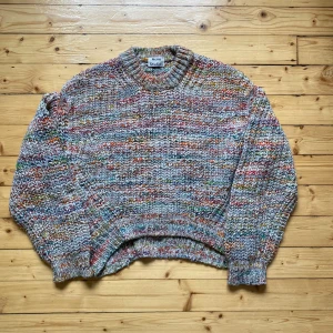 Acne Studios - Zora Multi Knit (M-L) - Säljer en snygg flerfärgad stickad tröja från Acne Studios. Tröjan har en härlig mix av färger som grå, röd, grön och orange. Den har en rund hals och långa ärmar med ribbade muddar. Taggad XS, väldigt oversized - passar M/L.