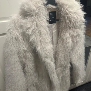 Pälsjacka  - Säljer en pälsjacka från Lager 157. Jackan har en fluffig och lyxig känsla med långa ärmar och en klassisk design. Perfekt för att hålla sig varm och trendig under kyliga dagar.