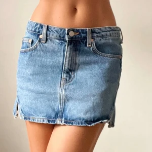 Blå långmidjad jeanskjol - Söt lågmidjad kjol i denim med slits på sidan från weekday. Storlek 36 men passar även mig som vanligtvis har 34