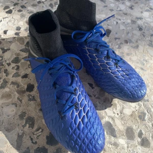 Nike hypervenom phantom 3 elite - Snygga blå fotbollsskor från Nike med svart strumpkrage och snörning. Skorna har en mönstrad ovansida för bättre grepp på bollen och en slitstark sula med dobbar för optimalt fäste på planen. Skick 8/10. Påse medkommer inte. Pris kan diskuteras!
