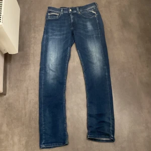 Replay hyperflex jeans - Snygga blå jeans från Replay i modellen Grover. De har en slim fit passform och är tillverkade i ett bekvämt denimtyg. Perfekta för en stilren look med klassiska femficksdetaljer och en diskret tvätt för en modern touch.
