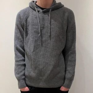 Grå stickad hoodie - En riktigt snygg stickad hoodie som inte görs längre. Den är i toppskick och har inga hål eller liknande. Hoodien är mörkgrå. Priset är inte hugget i sten.