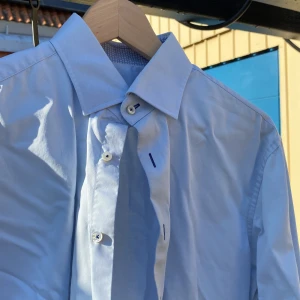 Klassisk ljusblå skjorta från Stenströms - Klassisk, snygg ljusblå skjorta från Stenströms i Twofold super cotton, fitted body. Skjortan har en klassisk krage och pärlemo knappar med kontrastsöm. 