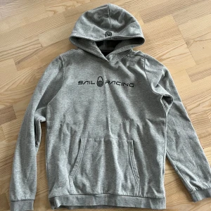 Grå hoodie från Sail Racing - Säljer en Sailracing hoodie som inte används mer , köpt från kidsbrandstore för 799 kr , storlek 176 motsvarar S. 