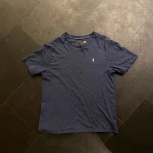 Blå t-shirt från Ralph Lauren - Säljer en klassisk blå t-shirt från Ralph Lauren med en liten broderad logga på bröstet. Storlek 160