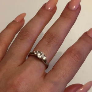 Ring - Äkta silverring 925 med tre gnistrande stenar i mitten och små stenar längs sidorna. 