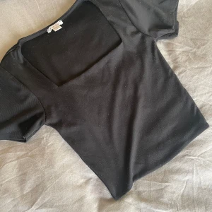 Svart kortärmad topp - Snygg svart topp från Zara med korta ärmar och fyrkantig halsringning. Perfekt för en stilren look.