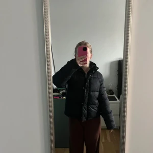 Svart pufferjacka Calvin Klein   - Säljer min Calvin Klein Monogram Tape puffer jacket med dragkedja och knappar. Jackan har en normal passform och är perfekt för kyligare väder - höst/vinter. Har en stilren design med sträck på sidorna med CK tryck. Nypris 1999:-. Pris kan diskuteras!  Artikelnr J20J212080-099