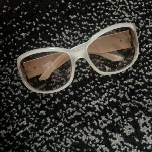 Vita solglasögon med transparenta bågar - Snygga vita solglasögon med transparenta bågar och breda skalmar. Perfekta för en stilren look och att skydda ögonen mot solen. De har en modern design som passar till många olika outfits.