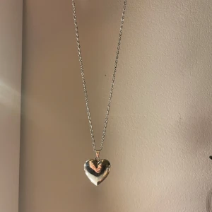 Halsband znt uf - Hjärthalsband som går att öppna för att spraya parfym på tyghjärtat som man sätter i för att den ska hålla hela dagen. Köpt av uf-företag så finns ej kvar. Rostfritt stål el sterling silver är osäker. Säljs i nyskick. Kedjan är 45 cm