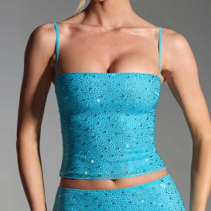Turkos paljettprydd tubtopp - Snygg turkos tubtopp med paljetter som ger en glittrig effekt. Toppen har smala axelband och en tight passform, perfekt för festliga tillfällen. Nypris 600kr, Oanvänd med lappar kvar