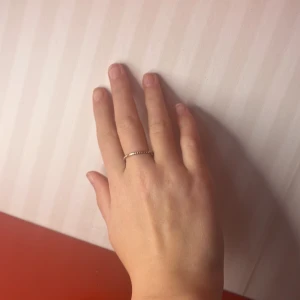 Elegant guldring - Säljer en stilren och elegant guldring. Ringen är tunn och har en enkel design som passar perfekt för alla tillfällen. Den är lätt och bekväm att bära.