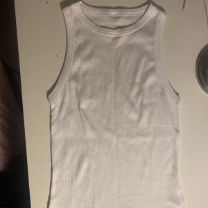 Vit ribbad linnetopp från Intimissimi - Säljer ett stilrent vit ribbad linne från Intimissimi. Linnet är gjort i 100% bomull och har aldrig andvänds.