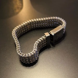 Jernhest armband - Ett stilrent och robust armband i rostfritt stål. Armbandet har en unik design med en flätad länk som ger en distinkt look. Spännet är graverat med jernhest logga. Perfekt för att komplettera din outfit.  https://jernhest.se/sv/armband/lankar-kedjor/jernhest-harley-armband-fiskben-silver.html