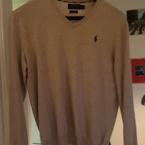 Beige, grå och rosa tröja från Ralph Lauren.  - Säljer schyssta tröjor från Ralph Lauren. Alla är väldigt bra skick men den grå tröjan har en sömm gått upp lite vid nacken se bifogad bild. 900kr för alla tre.