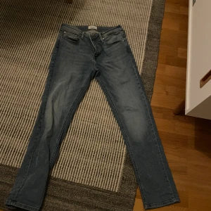 Blå jeans från Regular/Clark - Säljer ett par snygga blå jeans från Jack and Jones. Modellen heter Regular/Clark. Skick: 9/10 inte använda många gånger
