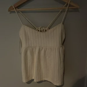 Knyt topp med öppen rygg - Krämvit tröja från Gina i väldigt bra skick som går att justera i ryggen. Tajt upptill och utsvängd nedtill. Jag tycker den sitter bekvämt även åtdragen. Säljer då den inte kommer till användning.💖