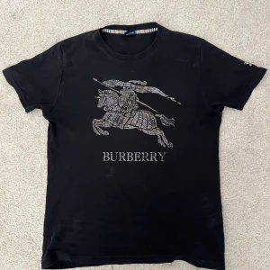Burberry T-Shirt - Säljer denna Burberry t shirten då jag aldrig använder den. Den är i bra skick. Den är äkta men har inget kvitto, därför så lågt pris. Den är lite dammig på bilden sorry  