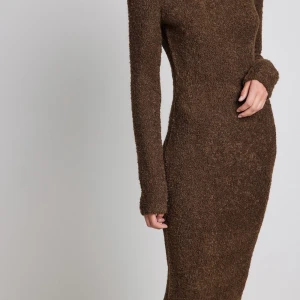 Klänning  - Brun, glittrigt, långärmad och rygglös klänning. Är från NA-KD och är ej använt. Klänningen är långt, passar nog bäst för personer mellan 160 - 167 cm. 