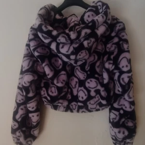 Fluffig kofta/jacka, H&M x The Smiley company  - Nästan aldrig använd och i bra skick. Den är lilla och svart